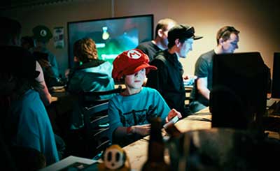 child wearing Mario hat playing video game